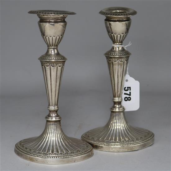 A pair of late Victorian fluted silver dwarf candlesticks, William Hutton & Sons, London 1897, weighted.